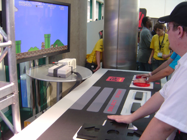 Ein Mann steht neben einem Fernseher.