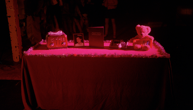 Ein Tisch mit einem TeddybÃ¤r, einem Buch, einem Bilderrahmen und diversen anderen GegenstÃ¤nden.