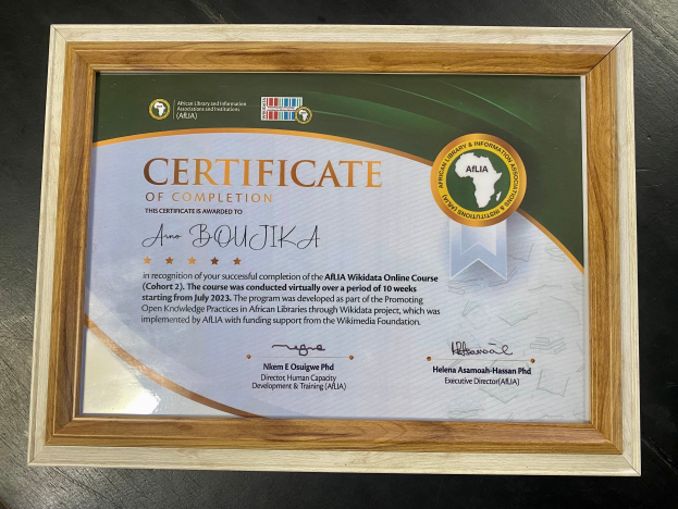 Ein gerahmtes Abschlusszertifikat auf einem Tisch mit Text, der den Abschluss angibt.