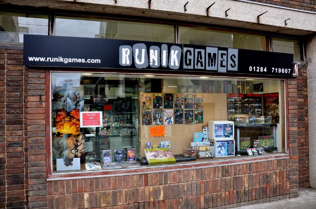 Eine Straße unten mit Wänden an der linken und rechten Ecke, ein Glasfenster mit verschiedenen Gegenständen und Text.