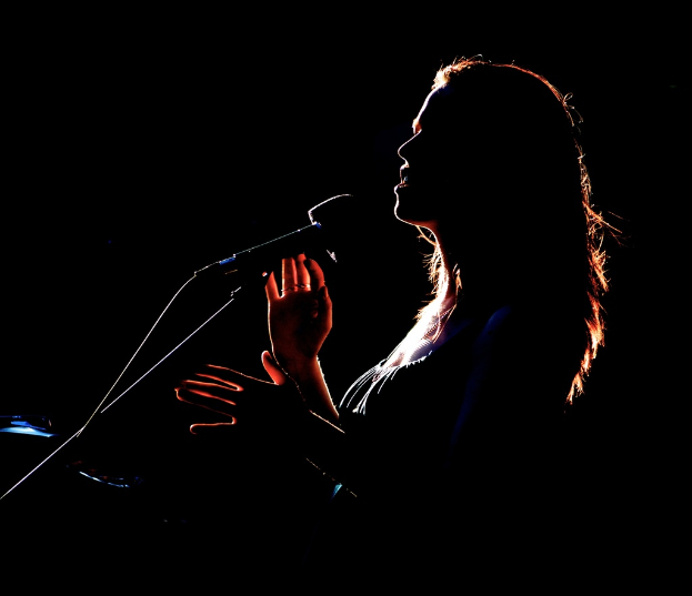 Ein Mädchen, das in ein Mikrofon singt.