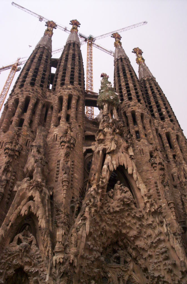 Ein Gebäude mit Türmen und Kränen unter einem klaren Himmel.