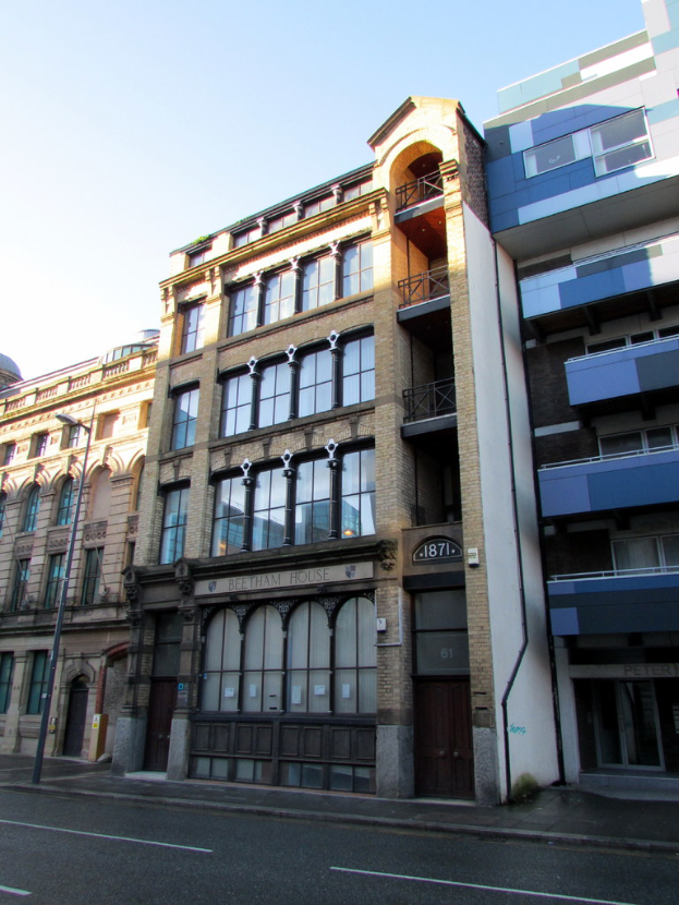 Mehrere Gebäude mit einem Pfahl in der linken Ecke und einer Straße davor.