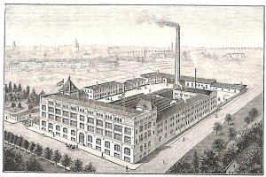 Alte Fabrik mit großem Hauptgebäude umgeben von Bäumen und Text unten.