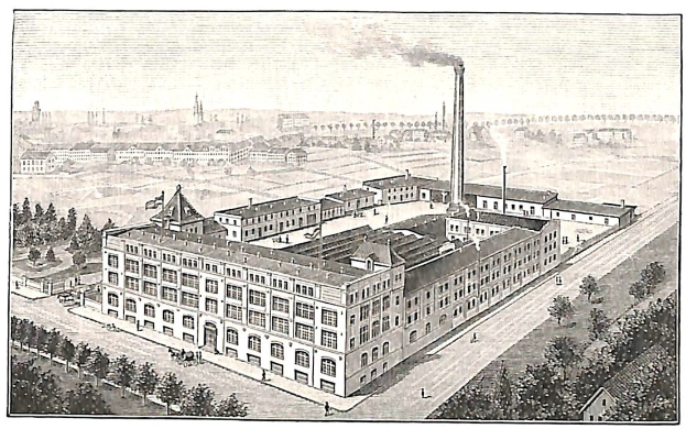 Alte Fabrik mit großem Hauptgebäude umgeben von Bäumen und Text unten.