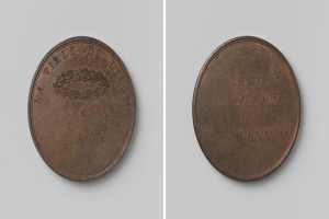 Eine Bronzemedaille mit der Inschrift "Trait de Courage" vor einem weißen Hintergrund.