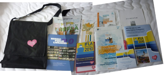 Eine Tasche mit 'Bibliotheksliebhaber' darauf und mehrere Bücher sind auf einem Bett platziert.