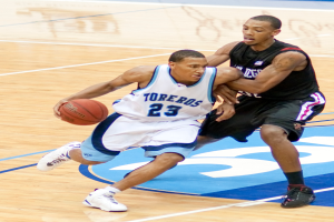 Zwei Personen spielen Basketball, wobei eine Person in der Mitte den Ball hält.