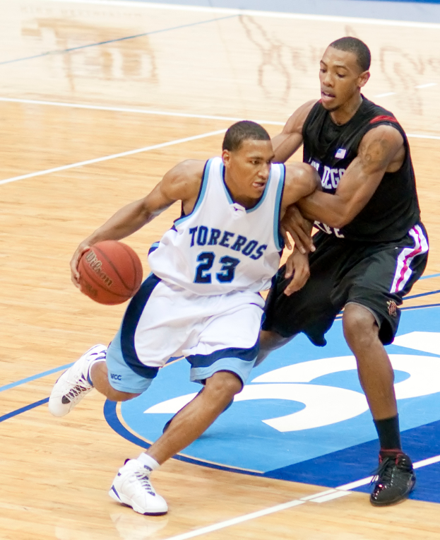 Zwei Personen spielen Basketball, wobei eine Person in der Mitte den Ball hält.