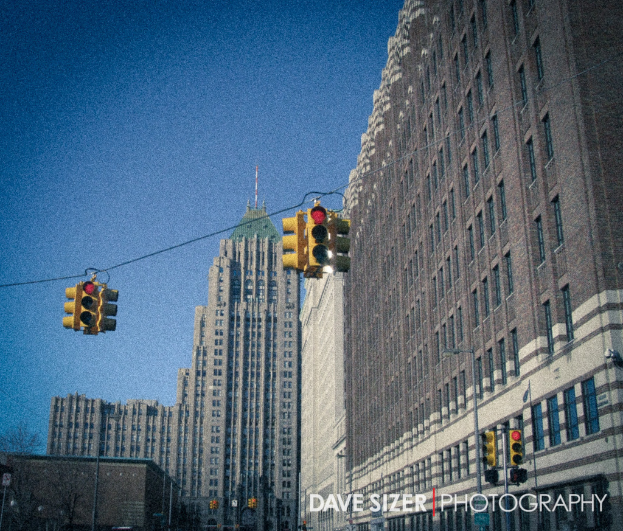 Mehrere Ampeln, Masten und Gebäude sind in einer urbanen Umgebung zu sehen.