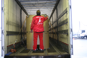 Eine Person mit einer Trommel im Inneren eines Lkw, mit ein paar Fahrzeugen im Hintergrund auf der Straße sichtbar.