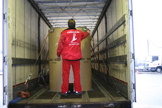 Eine Person mit einer Trommel im Inneren eines Lkw, mit ein paar Fahrzeugen im Hintergrund auf der Straße sichtbar.