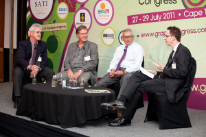 Vier Personen sitzen auf Stühlen und unterhalten sich.