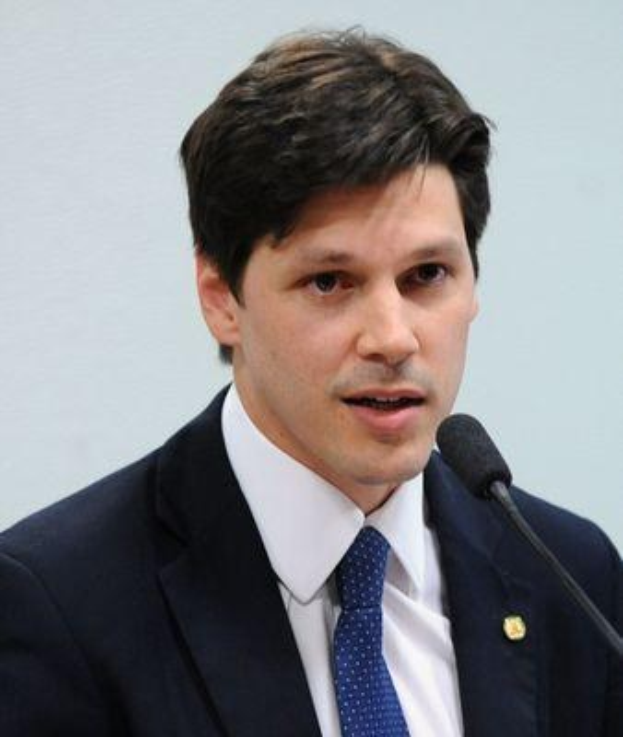 Ein Mann im Anzug und Krawatte spricht in ein Mikrofon an einem Rednerpult und scheint die Nachricht von einem vom Staat genehmigten Gesetz zur Internet-Sperre zu verkünden.