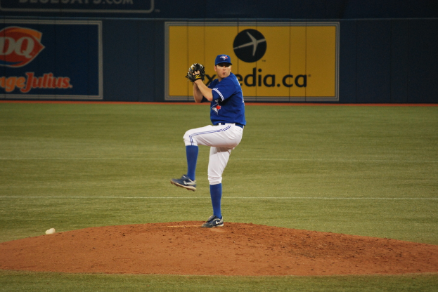 Eine Person steht auf dem Boden und hält einen Ball, mit einem großen Banner im Hintergrund, das Text und Bilder zeigt.