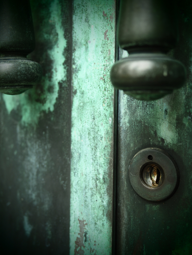 Eine Brücke überspannt einen Fluss mit zahlreichen Straßenlaternen darauf und im Hintergrund sind Gebäude zu sehen.