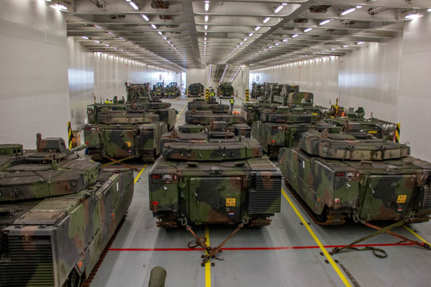 Ein grosser Militaraerraum mit Reihen von Militaraerfahrzeugen, Wanden auf beiden Seiten und Deckenbeleuchtung.