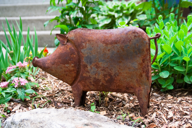 Eine Schweinefigur aus Eisen auf dem Boden.