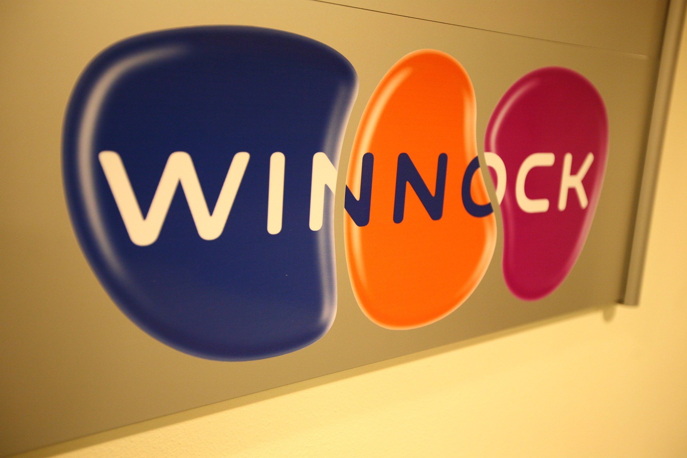 Leuchtend buntes "Winnock"-Schild an einer Wand, das einen Börsenplatz anzeigt.