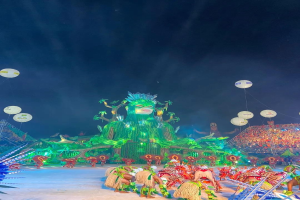 Ein farbenfroher Karneval in Rio de Janeiro, Brasilien, mit Performern in bunten Kostümen auf der Bühne, einer großen Menge im Publikum und einem Himmel voller bunter Lichter und Ballons.