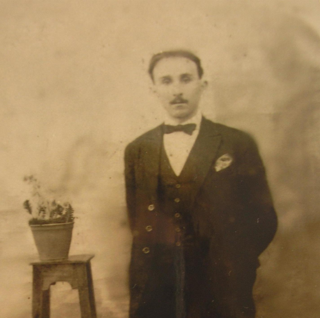 Ein Schwarz-Weiß-Foto eines Mannes im Smoking, der neben einem Topfpalmenständer steht, betitelt mit "Vater der Braut".