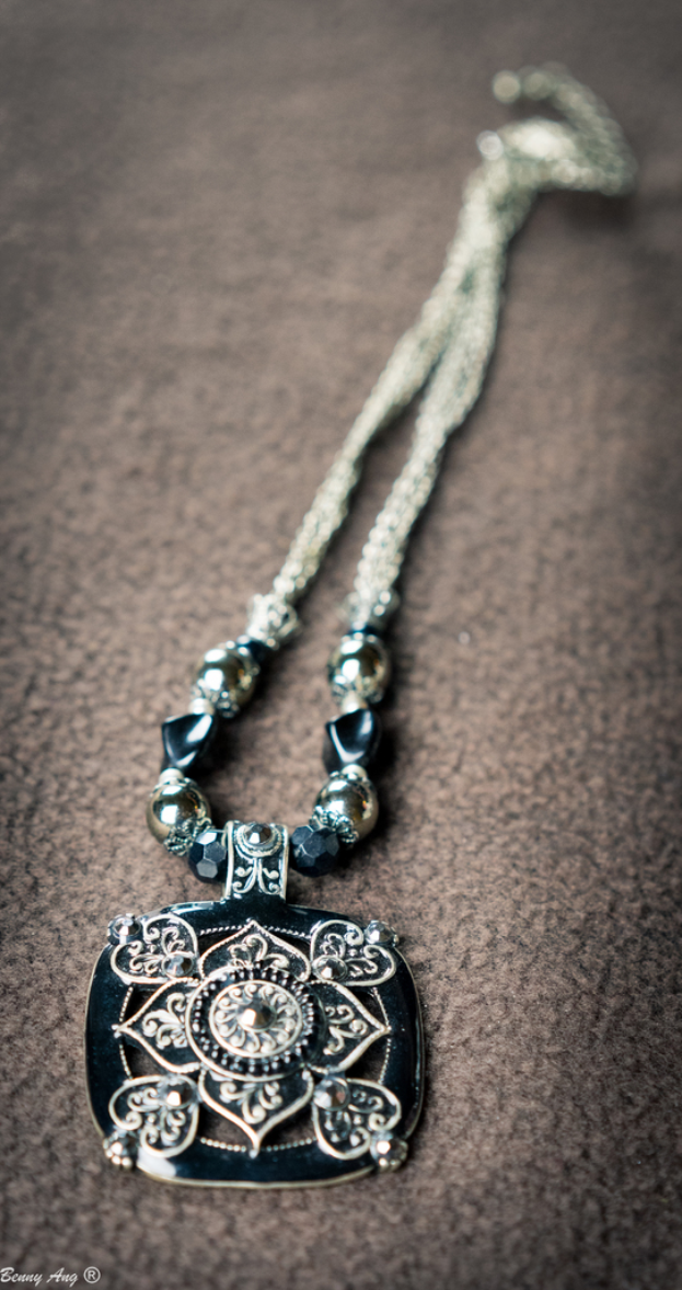 Ein Schmuckstück mit einer matten Basis und Text unten links.