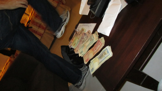 Ein Mann geht neben einem Tisch mit Geld und einem Telefon.