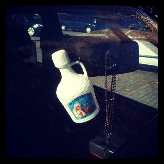 Ein Auto steht auf der Seite einer Straße mit einer Kette und einer Flasche in der Nähe.