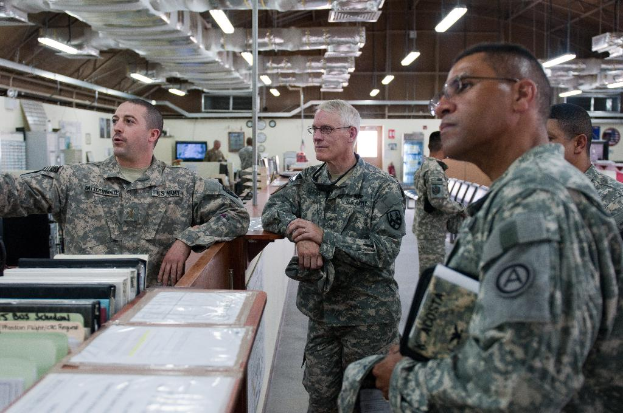 Soldaten in einem Raum mit Büchern, einem Fernseher an der Wand und einem Schuppen mit Lichtern oben.