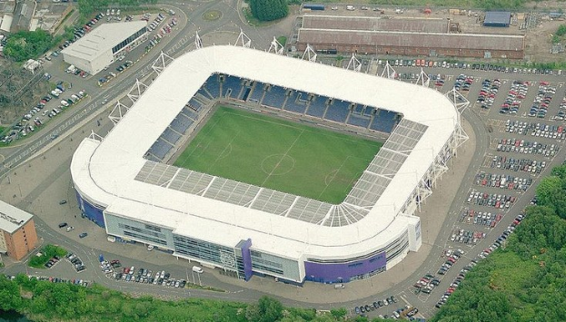 Luftaufnahme des Stadions von Tottenham Hotspur Football Club, umgeben von Stadtgebäuden, Bäumen und Straßen mit Fahrzeugen.