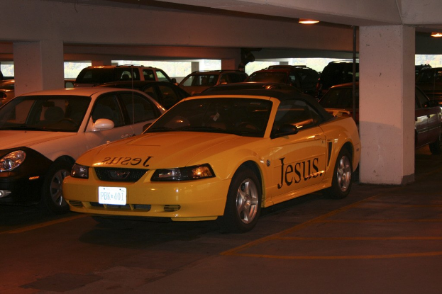Ein Parkplatz voller numerous geparkter Autos vor einem Gebäude.