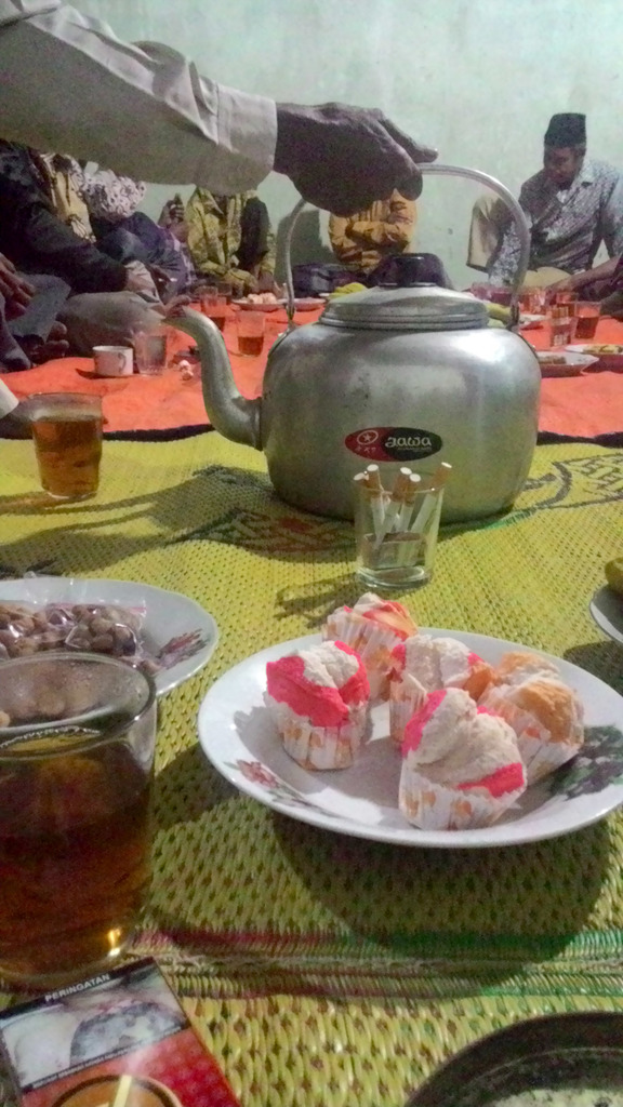 Ein spärlich besetzter Raum mit einem Tisch, der mit Tellern, Gläsern und Lebensmitteln gedeckt ist.