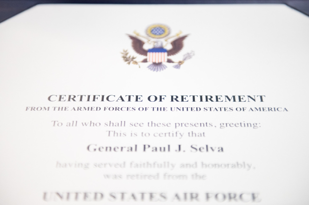 Rahmenurkunde für den Ruhestand von der United States Air Force mit blauem Rand, schwarzer Schrift und einem zentralen Schild-Logo mit einem Stern, Lorbeerkranz und einer 'Ruhestand'-Banderole.