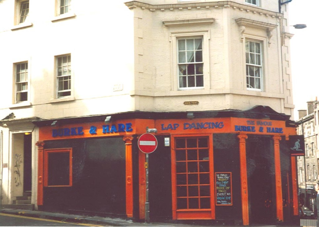 Ein Gebäude mit Fenstern, Türen und Text auf seiner Fassade.