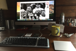 Ein Tisch mit elektronischen Geräten und einem Desktop-Computer, auf dem ein Video abgespielt wird.