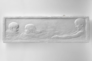 Drei Kinder beim Schwimmen in Wasser, mit einer Wand im Hintergrund, dargestellt auf einem Schwarz-Weiß-Foto.